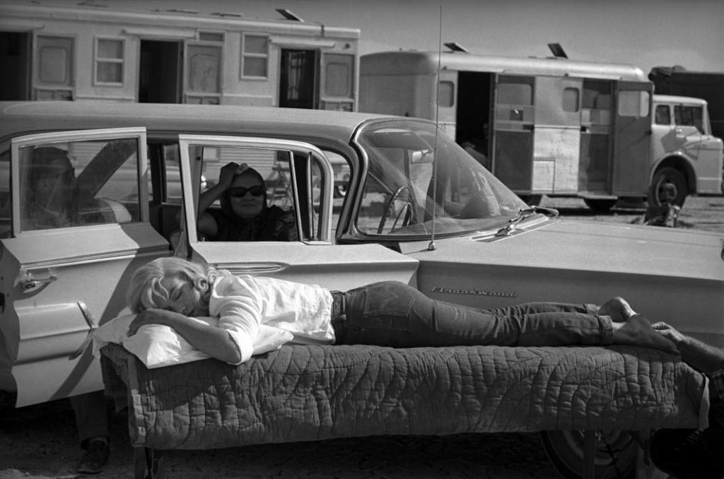 UNITED STATES. Nevada. American actress Marilyn Monroe rests between takes under the supervision of Paula STRASBERG, Monroe's drama coach, on the set of "The Misfits" by John HUSTON. 1960. EVE ARNOLD